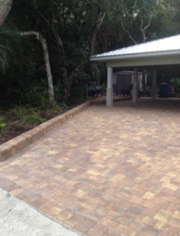 stone patio leading up to and under the carport