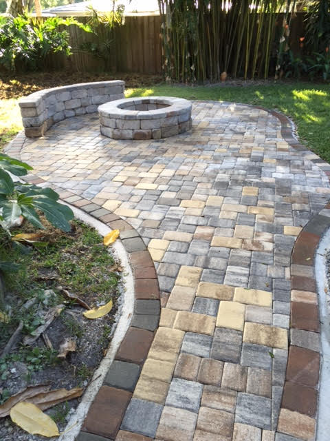 Stone patio with a stone firepit and stone bench